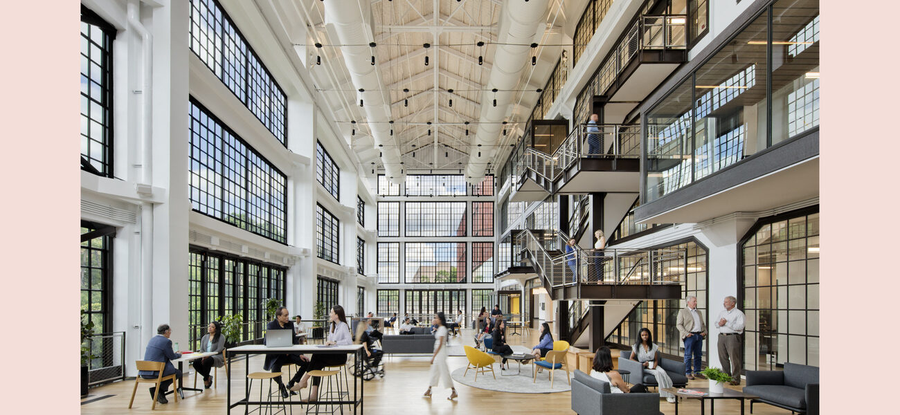 Large three-story interior space with a wall of windows on the left and balconies and staircases on the right