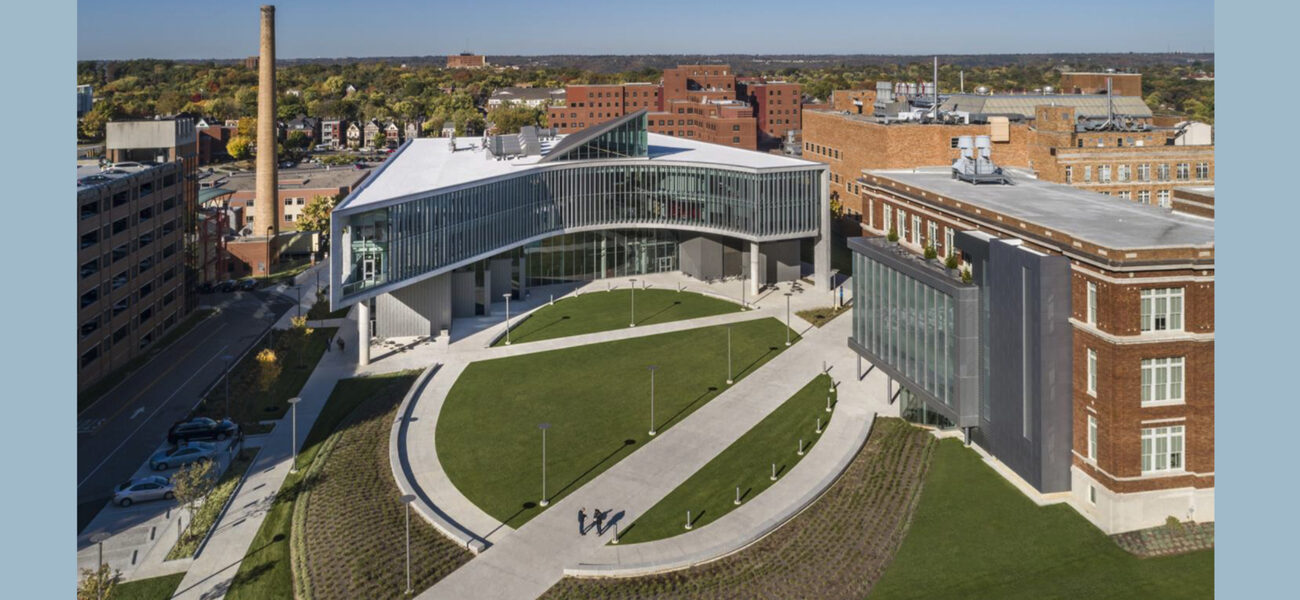 Aerial view of a large, round green space bounded on three sides by academic buildings.