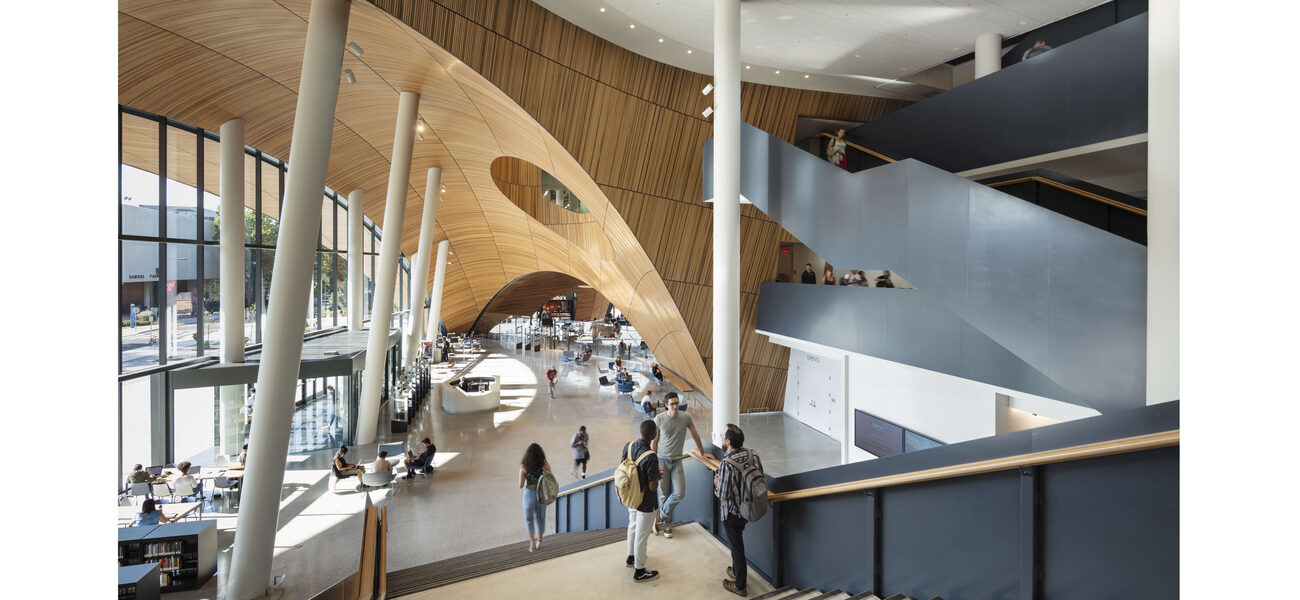 Students walk down a long staircase leading to a large open space.