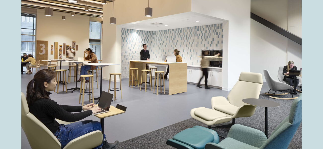Students work in a room with comfortable chairs, small tables and bar-height stools