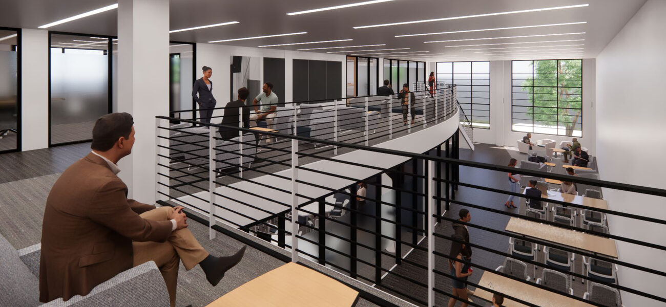 People gather on a balcony space overlooking a space with tables and chairs.
