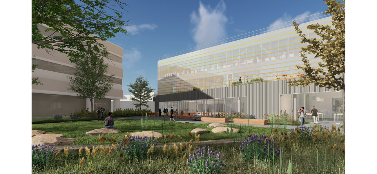 Building exterior with a garden in front and people milling about