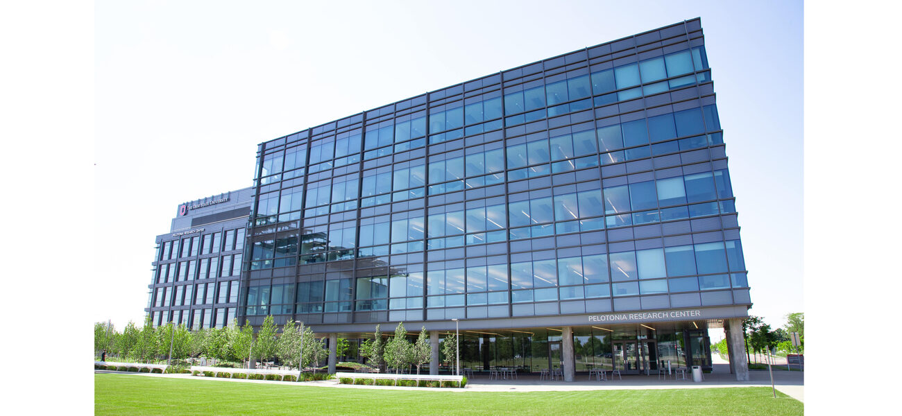 Large glass building with a lawn in front