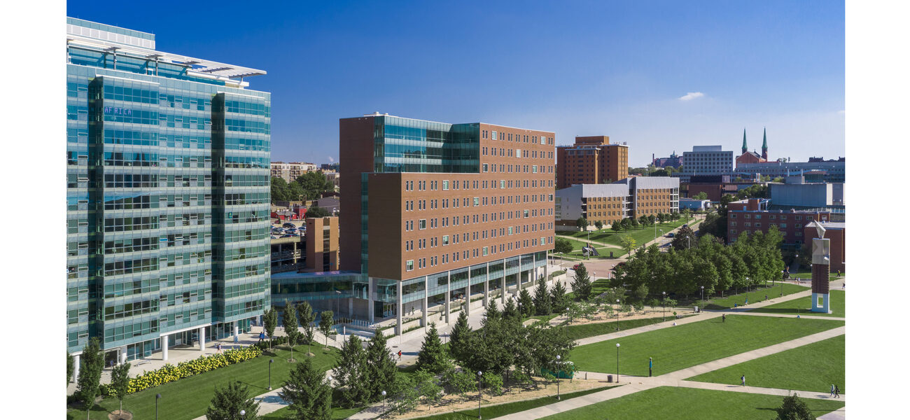 A large brick building with expansive lawns and walkways in front of it.