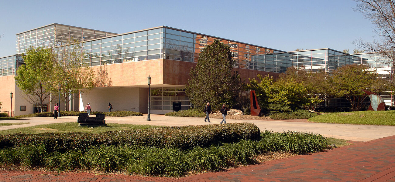 Concrete and glass building with a brick sidewalk in front.