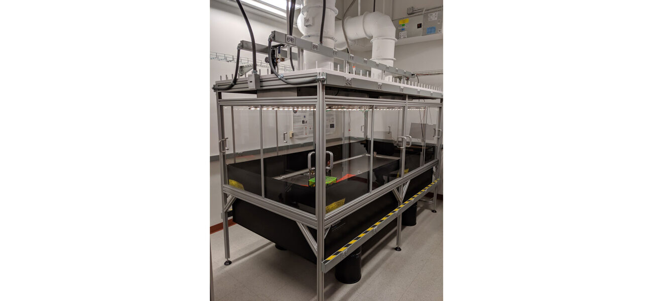 A piece of lab equipment is enclosed in a glass and steel box.