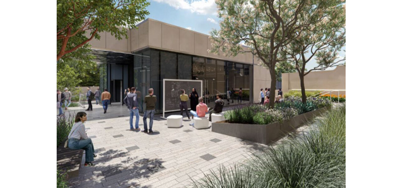 Several people mill around an outdoor patio with a building behind them.
