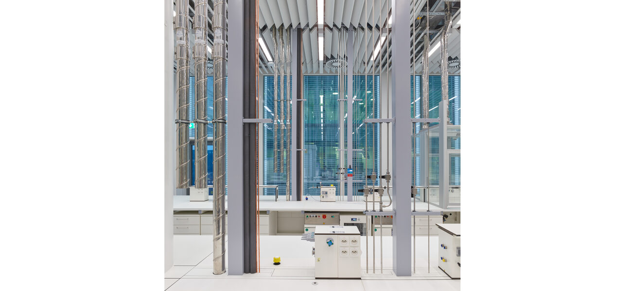 Wires and hoses extend from the lab ceiling to the benches below.