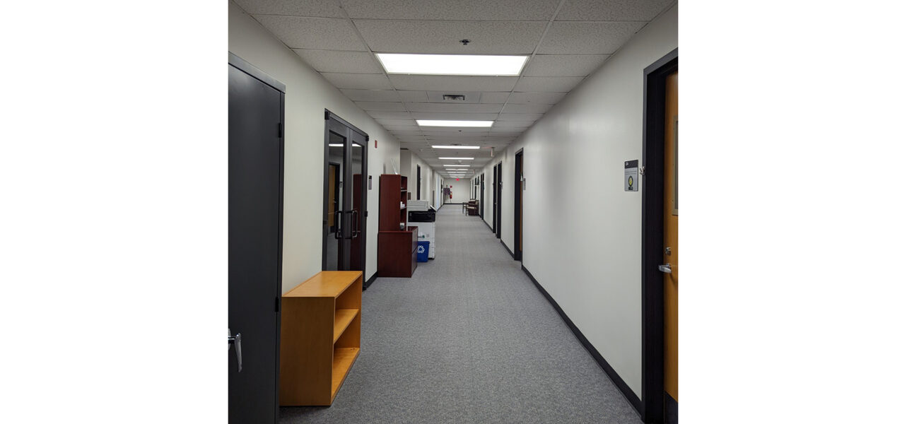 Long hallway lined with closed wooden doors,