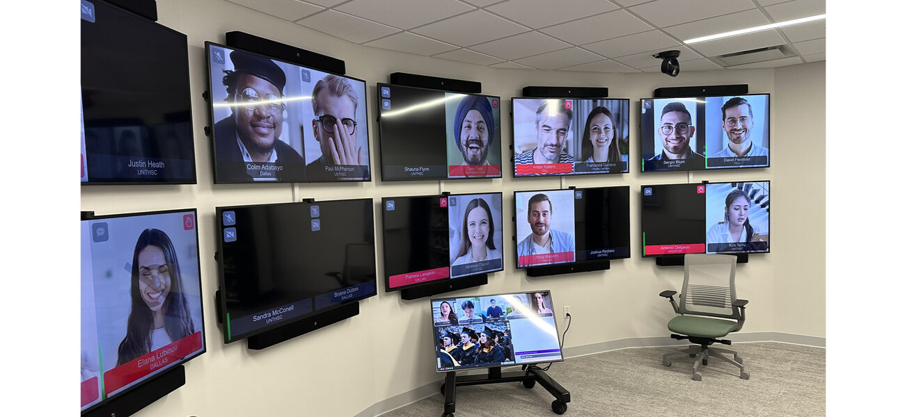 A bank of computer screens lines a curved wall.