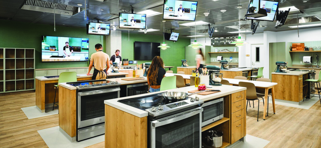 A large room containing several countertops complete with ovens and stovetops.