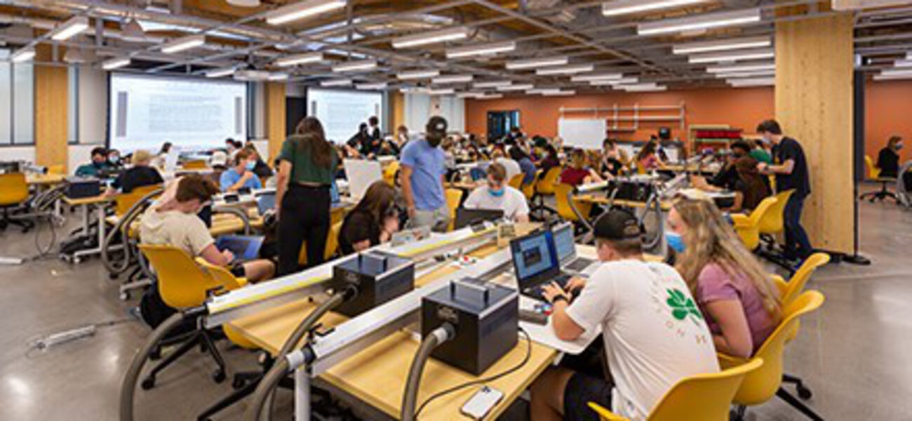 A large room filled with young men and women working on computers