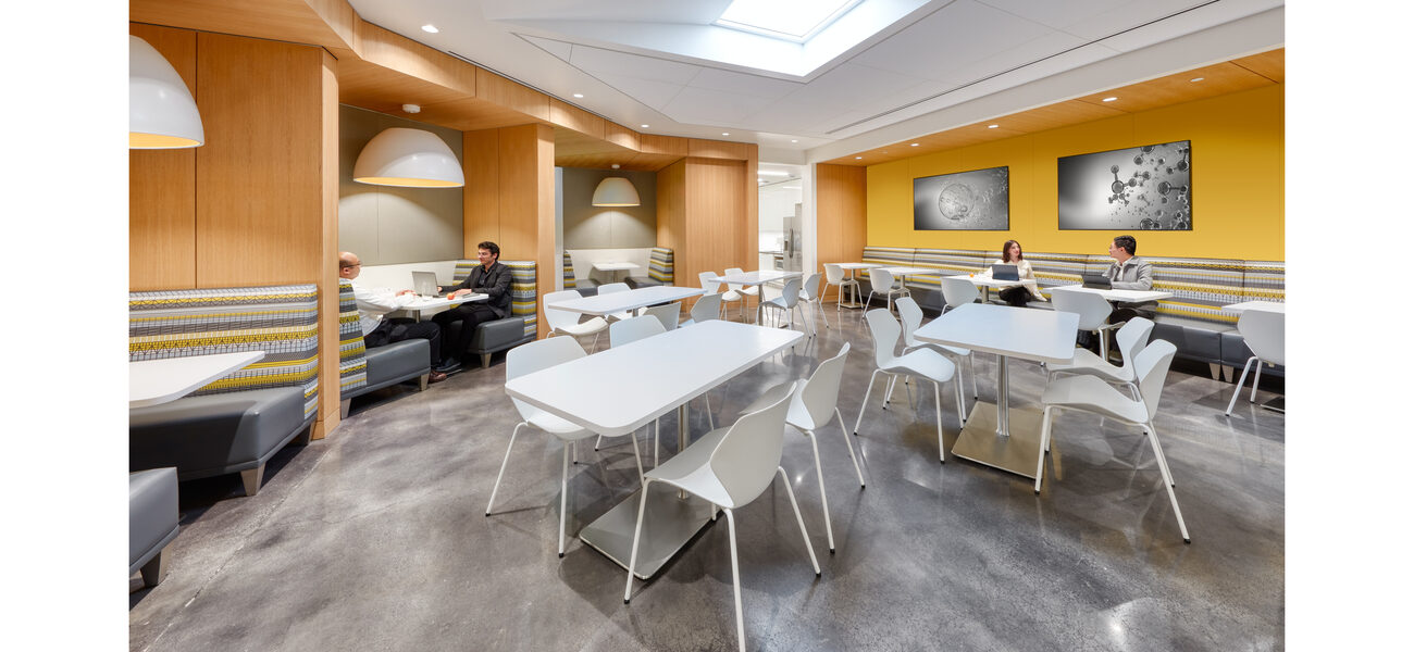 four people sit at small tables in rom that also includes larger tables