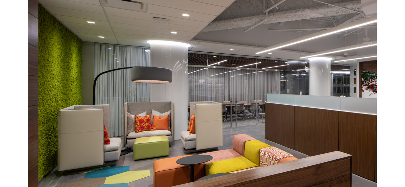 A room with one glass wall, soft seats and small tables