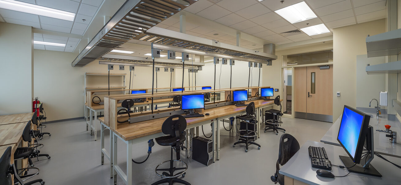 A large metal structure runs along the length and width of a laboratory ceiling