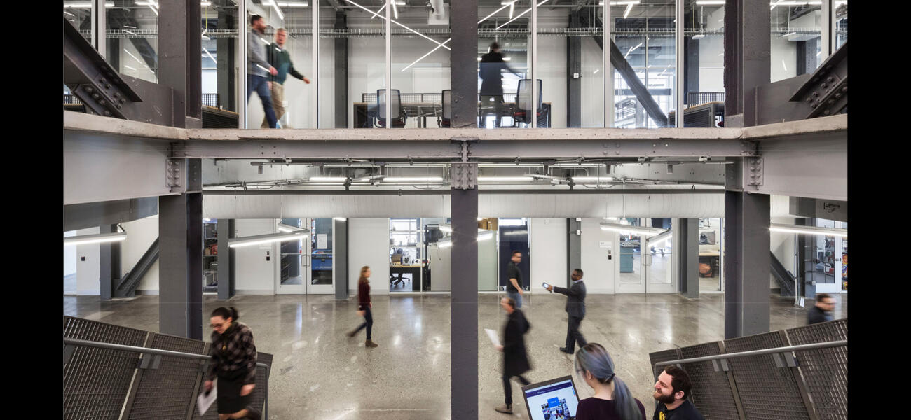 Men and women walking through a wide hallway on two levels.