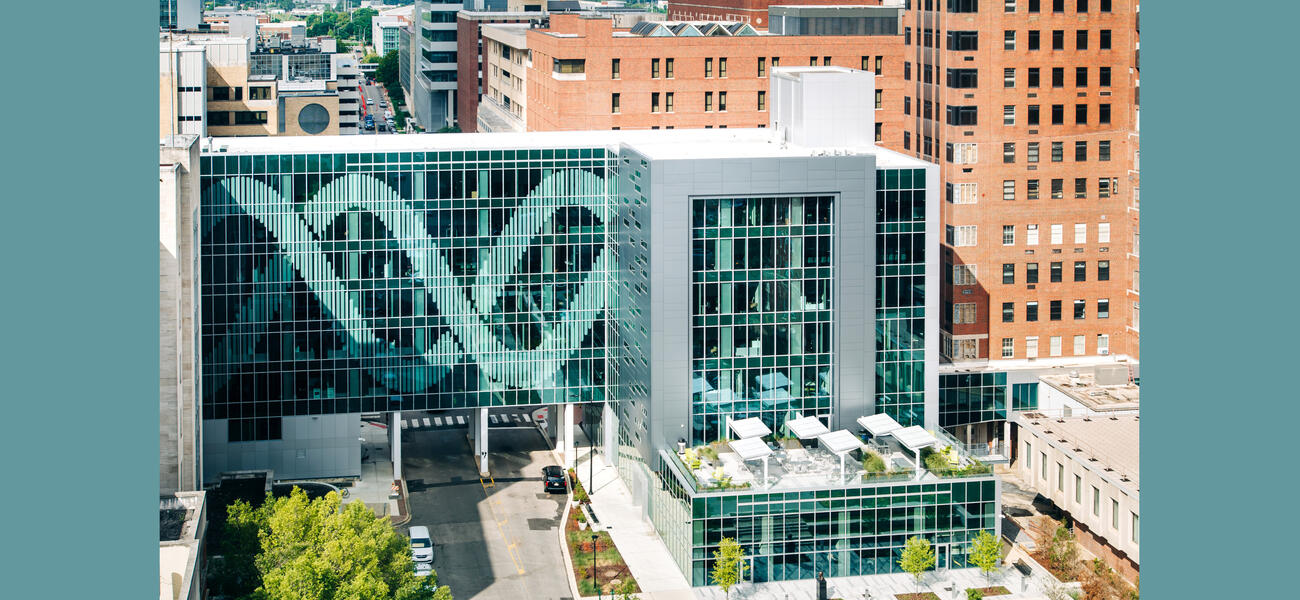 Building excterior covered in glass, with a one side decorated in a double helix pattern.