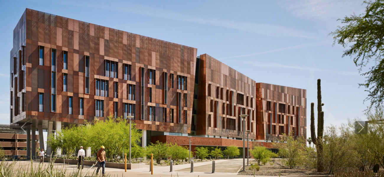 Large, multi-level building in three connected sections, with thin vertical windows