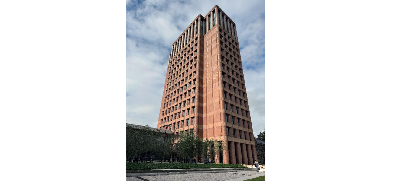 Exterior of a tall, thin tower constructed of brick and lined with small windows.