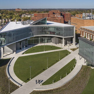 Aerial view of a large, round green space bounded on three sides by academic buildings.