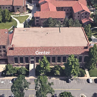 Aerial view of the building exterior, showing the tower on the left, the east wing on the right and a center section between them.