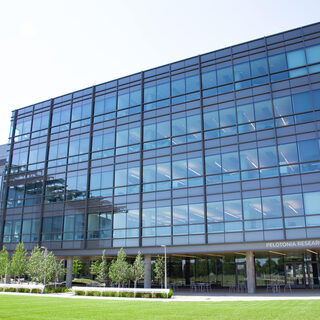 Large glass building with a lawn in front
