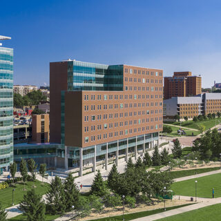 A large brick building with expansive lawns and walkways in front of it.