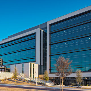 Long thin building framed in concrete and clad in glass.