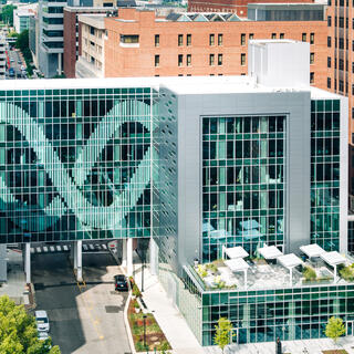 Building excterior covered in glass, with a one side decorated in a double helix pattern.