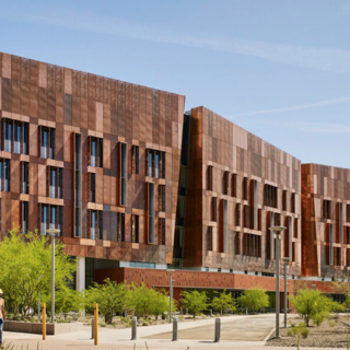 Large, multi-level building in three connected sections, with thin vertical windows