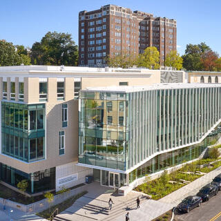 Long building lined with wondows on one side and almost entirely by glass on thw other.