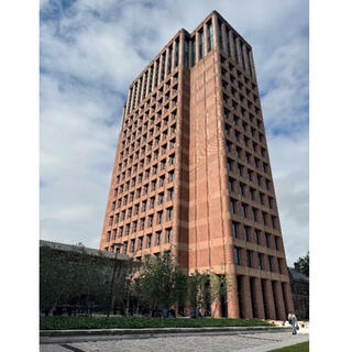 Exterior of a tall, thin tower constructed of brick and lined with small windows.
